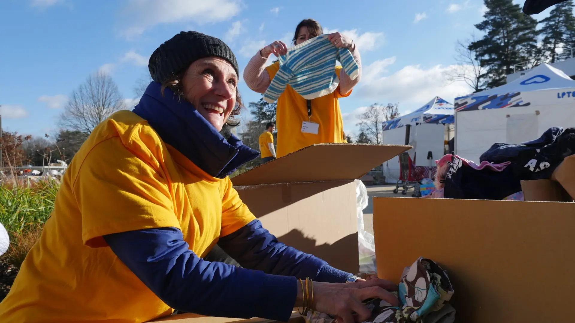 Bénévole portant un carton de dons lors d'une collecte